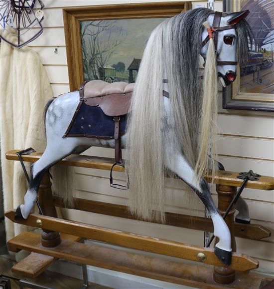A Stevenson Brothers, 1994, dapple painted carved wood rocking horse on supports W.142cm